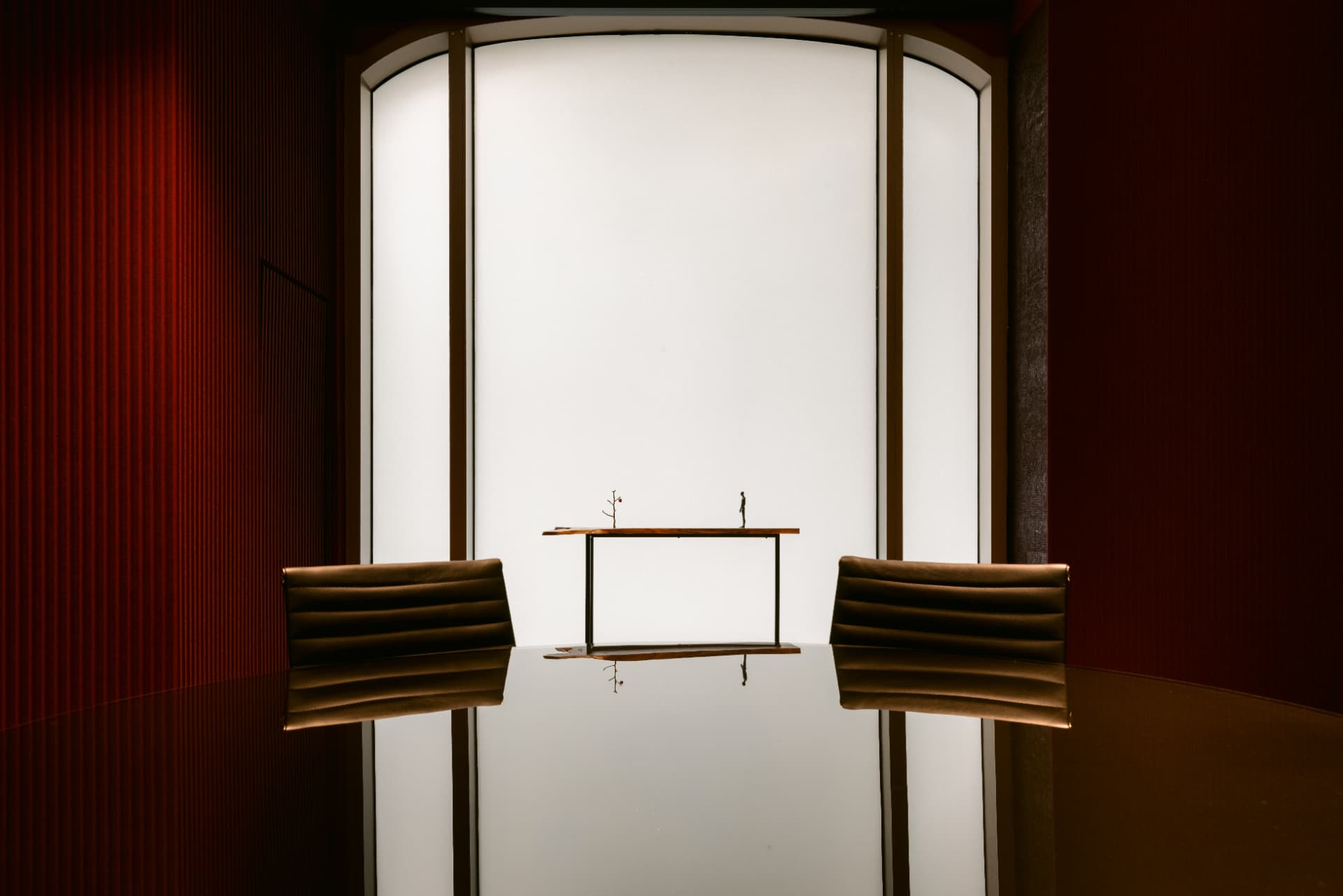 The Globacor boardroom, two chairs facing each other across a dark polished table beneath an arched window