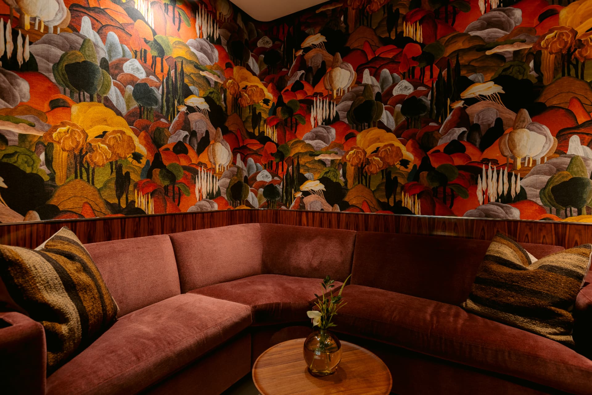 A private sitting room in the Globacor office, with a velvet banquette beneath a hand-painted landscape mural